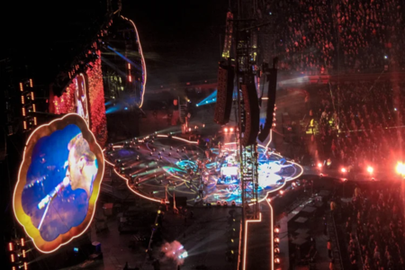 Stage at concert/festival with bright lights and a large crowd